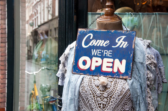 Mannequin with an open sign in a store window