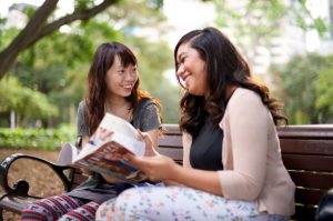 two friends share a magazine