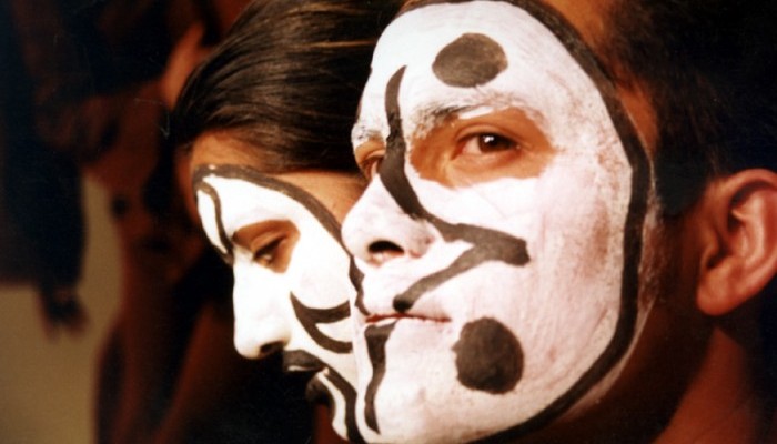 Men with painted faces learn patience while performing in a play
