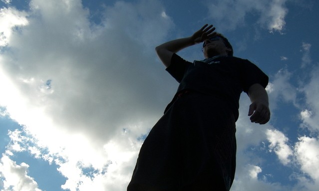 Man looks out to horizon blue sky background