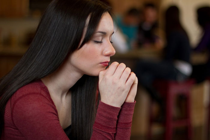 Young woman with trust of God praying