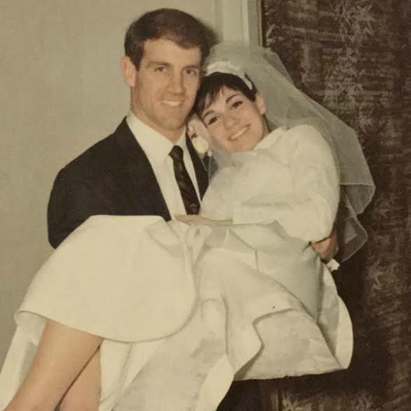 A happy groom carrying his bride