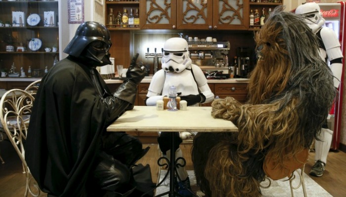 Darth Vader, Chewbaca, and a Storm Trooper at a table