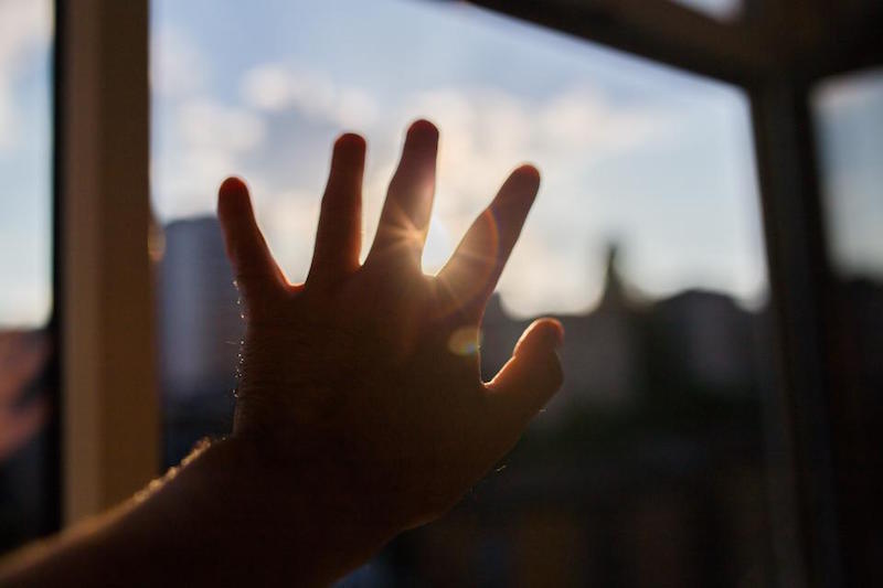 a hand reaching for the sun in hope