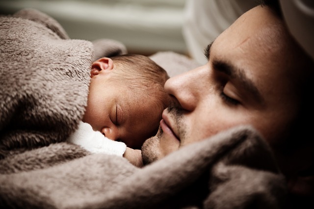 Father holds infant on chest