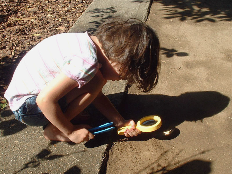 girl using magnifying glass compares to how to magnify your calling