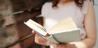 teen holds a great book