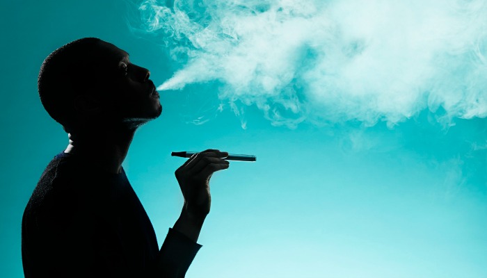 man on blue background smoke e-cigarette