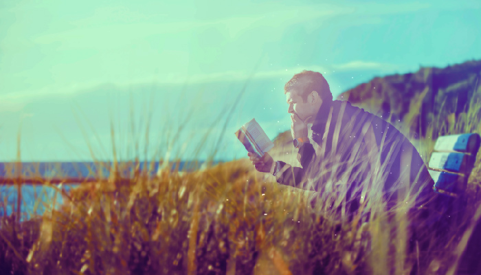 man by a lake reading