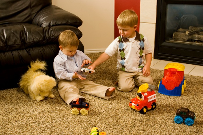 two boys playing with cars