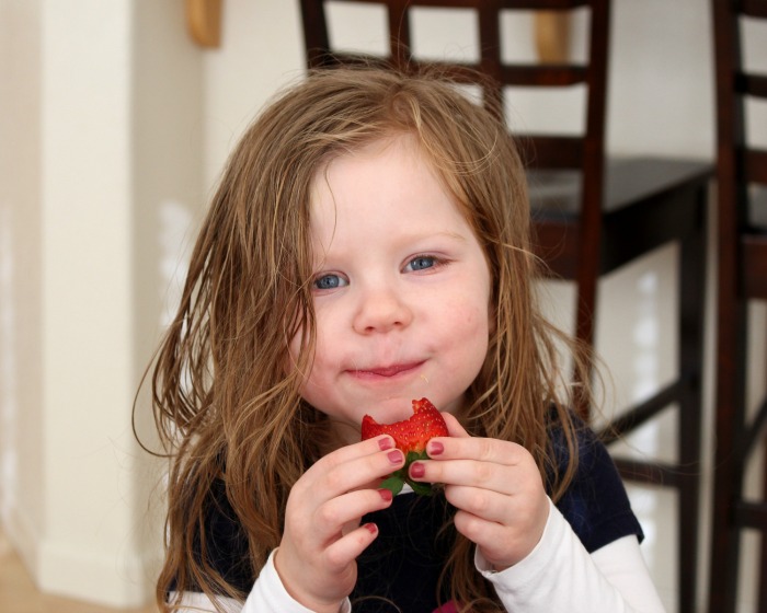 girl eating strawberry