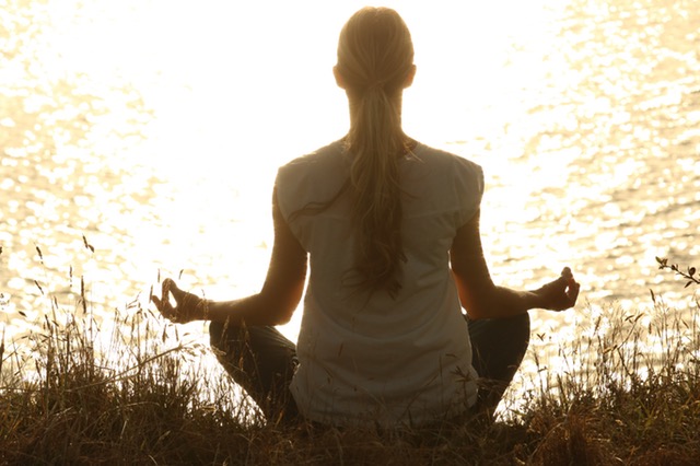 Woman Practicing Meditation on riverbank