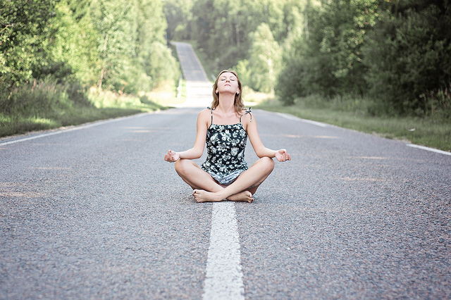 Woman practicing meditation on open road
