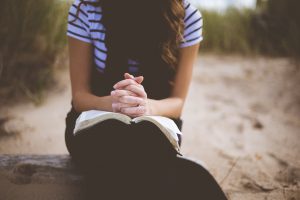 Woman praying on beach