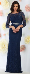 A woman wears a floor-length navy prom dress.