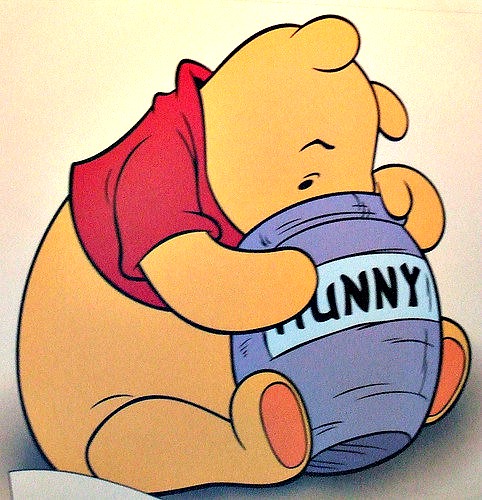 Winnie the Pooh with his face in a pot of Hunny