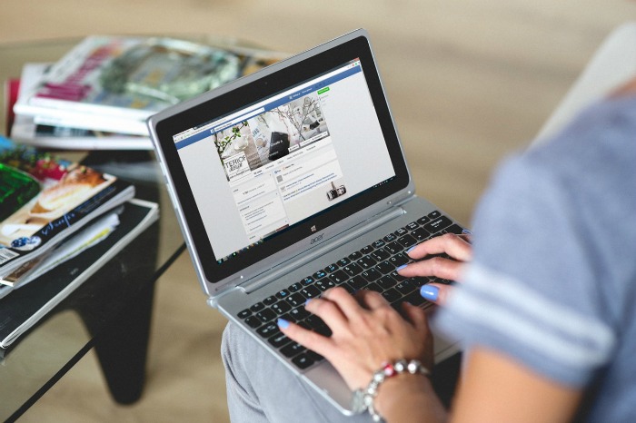 A woman views social media on her laptop.