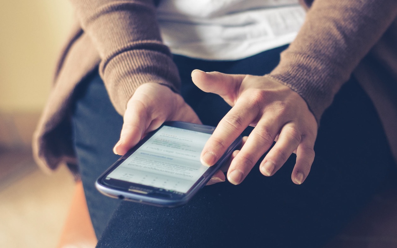 A woman views media on her smartphone.