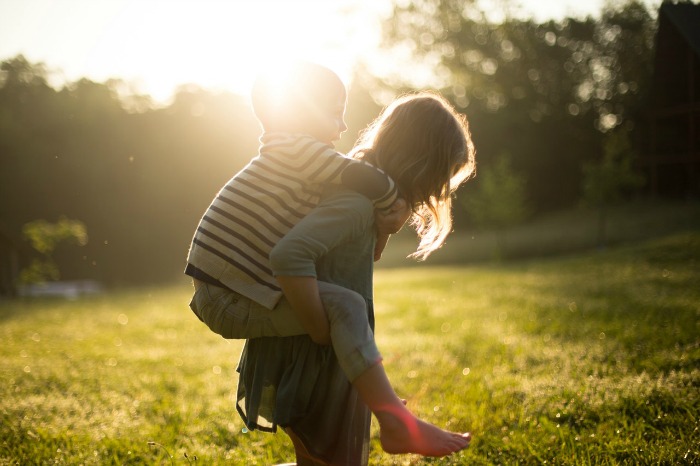 A child giving another child a piggyback ride