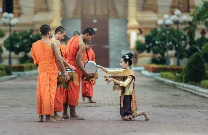 A woman gives to Theravada Buddhist monks