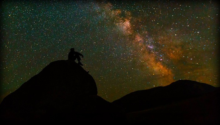 Silhouette of man thinking under stars
