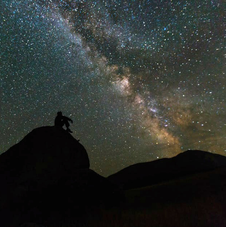 man outdoors gazing at the milky way