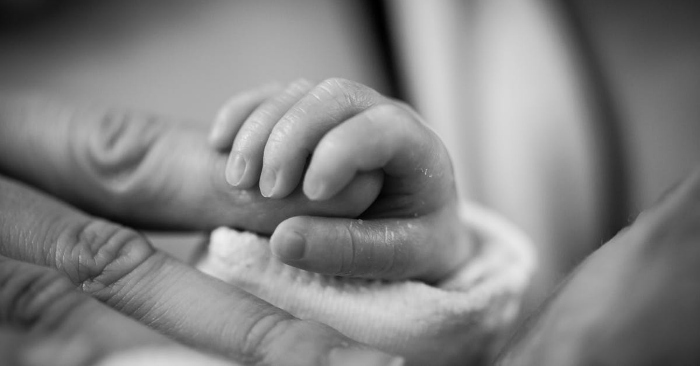 Baby holding mother's finger