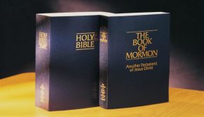Holy Bible and Book of Mormon standing together on a table