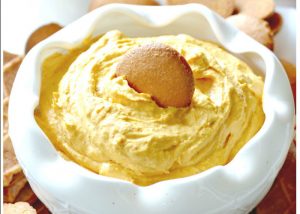 A unique shaped bowl (divited edges) holds pumpkin pie dip with a vanilla wafer at it's apex