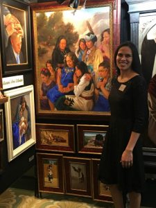 Artist Kwani Povi Winder poses with her art display at the Inspirational Art Association's 8th Annual Joseph Smith Memorial Building Christmas Art Showcase.