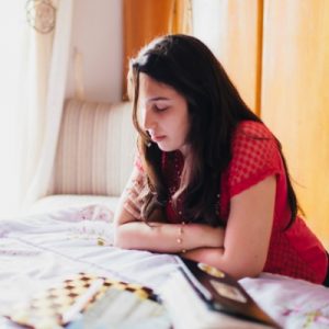 mujer rezando junto a la cama