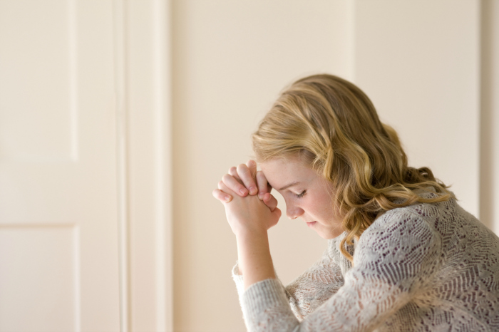 young woman praying mean girls bullying church