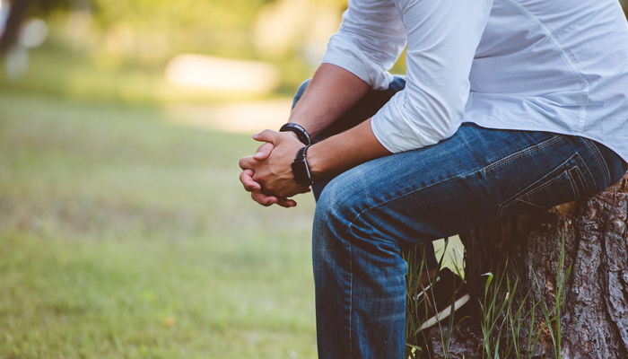 man sitting outside praying