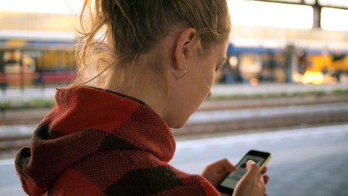 Girl texting with a red coat on 