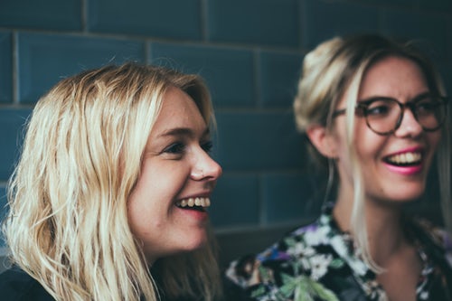 Two blonde girls sitting and chatting in Norwich