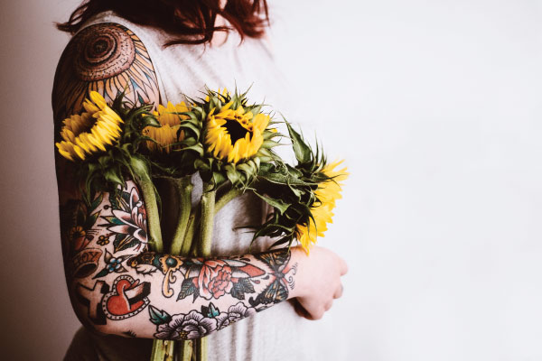 tattooed arm holding flowers