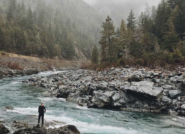 man standing river wild