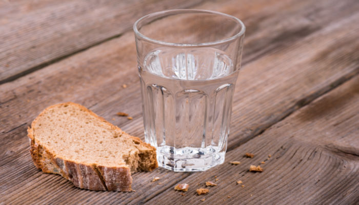 Glass of water and broken bread