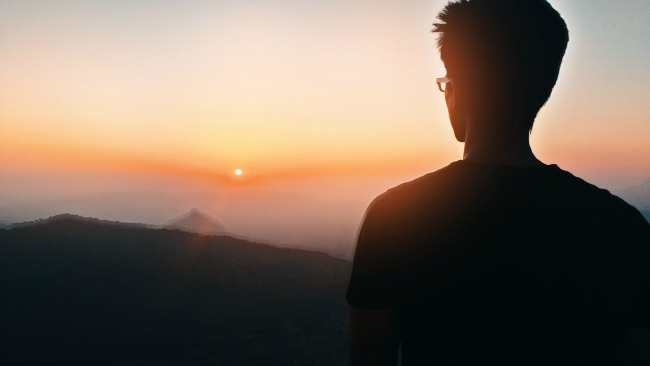 young man watching sunset