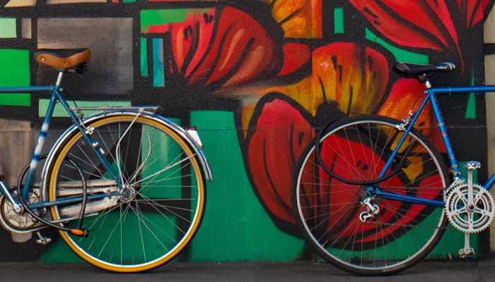 Bikes in front of a wall of graffiti.