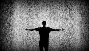 Silhouette of man standing in rain.