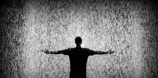 Silhouette of man standing in rain.