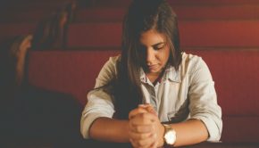 Girl sitting in church pews without sacrament