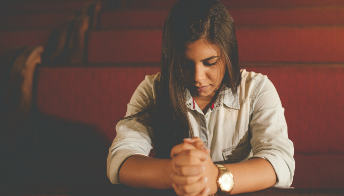 Girl sitting in church pews without sacrament