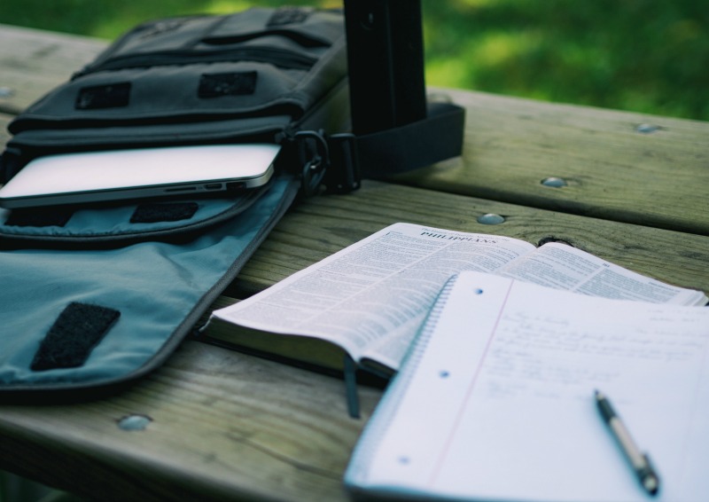 table with laptop, scriptures, and a notebook on top