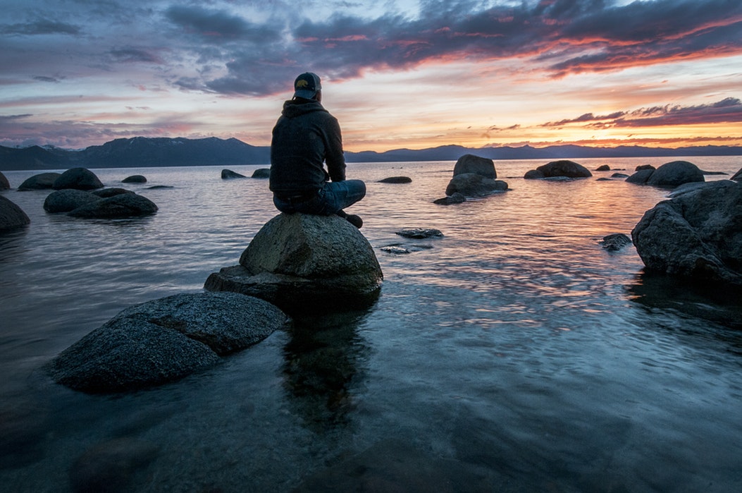 Man sitting on rock patience