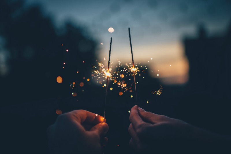 two people holding sparklers