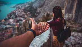 man holding wife's hand on mountainside