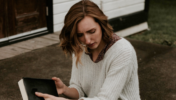 Woman stressed holding scriptures.