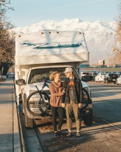couple in front of truck bed camper